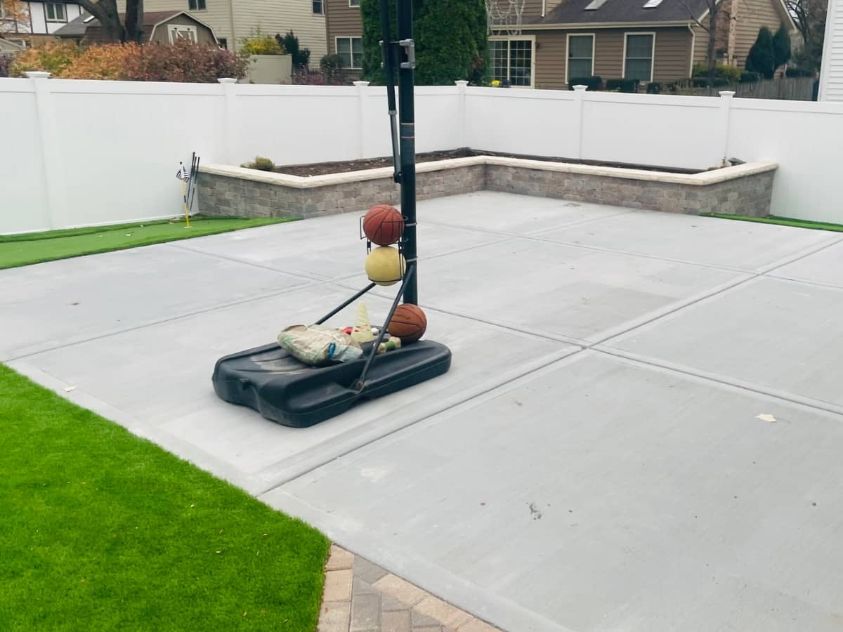 concrete backyard patio with basketball hoop
