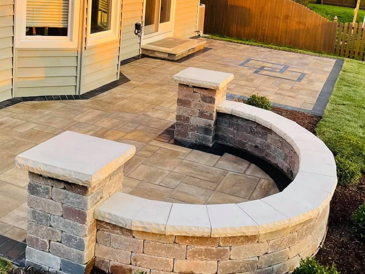 custom paver patio with curved brick seating wall in backyard